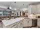 Open kitchen with a large island, quartz countertops, stainless steel appliances, and a view to the living room at 3519 Arlington Ridge Blvd, Leesburg, FL 34748