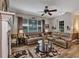 Spacious living room features hardwood floors, large windows, fireplace, ceiling fan and leather couches at 3519 Arlington Ridge Blvd, Leesburg, FL 34748