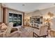 Cozy living room featuring plush seating, a decorative media center, and a sliding glass door to the patio at 3519 Arlington Ridge Blvd, Leesburg, FL 34748