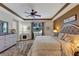 Spacious main bedroom featuring a tray ceiling, accent wall, ceiling fan, hardwood floors, and plenty of natural light at 3519 Arlington Ridge Blvd, Leesburg, FL 34748