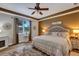 Comfortable main bedroom with a tray ceiling, accent wall, hardwood floors, plenty of light, and a ceiling fan at 3519 Arlington Ridge Blvd, Leesburg, FL 34748
