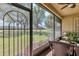 Inviting screened patio with wicker furniture and a view of the well-manicured lawn and lush greenery, a serene retreat at 3519 Arlington Ridge Blvd, Leesburg, FL 34748