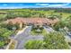 Aerial view of the community clubhouse featuring lush landscaping, water feature, and ample parking at 3550 Fairwaters Ct # D, Clermont, FL 34711