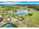 Stunning aerial view showcasing the community's lake, walking paths, tennis courts, and lush landscaping at 3550 Fairwaters Ct # D, Clermont, FL 34711