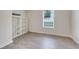 Minimalist bedroom with tile floor, large window, and white shelving unit for storage at 3550 Fairwaters Ct # D, Clermont, FL 34711