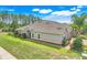 Well-maintained home with manicured lawn, mature trees, and an American flag displayed, creating curb appeal at 3550 Fairwaters Ct # D, Clermont, FL 34711