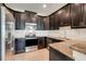 Sleek kitchen with dark cabinetry, granite counters, and stainless steel appliances at 3550 Fairwaters Ct # D, Clermont, FL 34711