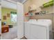 Convenient laundry room with shelving, washer, dryer, and doorway to bedroom at 3550 Fairwaters Ct # D, Clermont, FL 34711