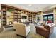 Comfortable living room with large bookshelves, plush seating, and a television for relaxing and entertaining at 3550 Fairwaters Ct # D, Clermont, FL 34711