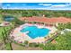 Aerial view of the community pool featuring chairs, tables, covered seating and meticulously landscaped grounds at 3550 Fairwaters Ct # D, Clermont, FL 34711