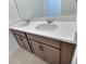 Bathroom featuring double sinks with a quartz countertop and dark wood cabinets at 358 Switchgrass Loop, Minneola, FL 34715