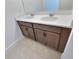 Bathroom featuring double sinks with a quartz countertop and dark wood cabinets at 358 Switchgrass Loop, Minneola, FL 34715