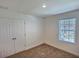 Bedroom with neutral carpet, white walls, a window, and double door closet at 358 Switchgrass Loop, Minneola, FL 34715