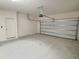 Spacious two-car garage with an automatic door and white walls at 358 Switchgrass Loop, Minneola, FL 34715