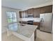 Open-concept kitchen featuring an island, stainless steel appliances, and dark cabinets at 358 Switchgrass Loop, Minneola, FL 34715