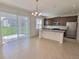 Open-concept kitchen featuring an island, stainless steel appliances, and sliding doors to the patio at 358 Switchgrass Loop, Minneola, FL 34715