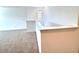 Loft area featuring neutral carpet and a banister with white trim at 358 Switchgrass Loop, Minneola, FL 34715