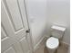 Toilet room with a white ceramic toilet and standard door and light switches at 358 Switchgrass Loop, Minneola, FL 34715