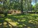 Spacious backyard featuring a well-maintained lawn, mature trees, and a charming single-story house at 365 Fletcher Ave, Daytona Beach, FL 32114