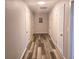Hallway featuring wood laminate flooring, neutral color, and multiple doors at 365 Fletcher Ave, Daytona Beach, FL 32114
