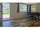 Living room view with door to outdoor deck, wood-look floors and a black grand piano at 365 Fletcher Ave, Daytona Beach, FL 32114