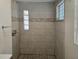 Shower stall featuring tile surround, glass block window, and pebble stone floor at 365 Fletcher Ave, Daytona Beach, FL 32114