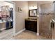 Bathroom featuring a dark wood vanity with granite countertop and a tiled shower with glass doors at 3809 Arlington Ridge Blvd, Leesburg, FL 34748