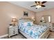 Charming bedroom with a decorative headboard, matching bedside tables, and a ceiling fan at 3809 Arlington Ridge Blvd, Leesburg, FL 34748