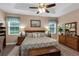 Comfortable primary bedroom with a tray ceiling, and a neutral color scheme with carpet at 3809 Arlington Ridge Blvd, Leesburg, FL 34748