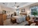 Cozy primary bedroom with tray ceilings, a neutral palette, and an ensuite bath at 3809 Arlington Ridge Blvd, Leesburg, FL 34748