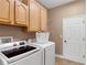 Bright laundry room with modern washer and dryer, ample cabinet space, and a convenient folding area at 3809 Arlington Ridge Blvd, Leesburg, FL 34748
