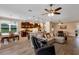 Open concept living room with hardwood flooring, fan, natural light, and view to the kitchen at 3809 Arlington Ridge Blvd, Leesburg, FL 34748