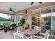 Relaxing screened patio with comfortable seating, a ceiling fan, and views of the lush golf course at 3809 Arlington Ridge Blvd, Leesburg, FL 34748