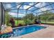 Gorgeous screened-in pool with a waterfall feature surrounded by lush landscaping and a golf course view at 3809 Arlington Ridge Blvd, Leesburg, FL 34748