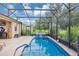 Beautiful screened-in pool with waterfall feature surrounded by lush greenery, offering a relaxing outdoor oasis at 3809 Arlington Ridge Blvd, Leesburg, FL 34748