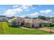Spacious single-story home with brick driveway, two-car garage, and beautiful landscaping under a blue sky at 39504 Hillrise Ln, Lady Lake, FL 32159