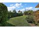 Manicured backyard with lush green lawn and mature trees and shrubs at 39504 Hillrise Ln, Lady Lake, FL 32159