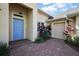Inviting front entrance with blue door, brick walkway, and a view of the garage and lush landscaping at 39504 Hillrise Ln, Lady Lake, FL 32159