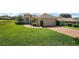 Well-manicured lawn and shrubbery surround a charming one-story home with a brick driveway and two-car garage at 39504 Hillrise Ln, Lady Lake, FL 32159