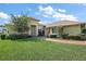 Inviting single-story home featuring lush landscaping, brick walkway, and a charming light yellow exterior at 39504 Hillrise Ln, Lady Lake, FL 32159