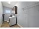 Well lit laundry room with cabinet and drying rack above the washer and dryer at 39504 Hillrise Ln, Lady Lake, FL 32159