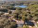 Stunning aerial view showcasing the home's lakeside location with mature trees and a sparkling swimming pool at 40140 Palm St, Lady Lake, FL 32159