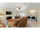 Open living room with a ceiling fan, television, washer and dryer area, and access to the backyard at 40140 Palm St, Lady Lake, FL 32159