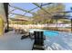 Backyard featuring a screened pool and lounging area offering a perfect setting for leisure and enjoyment at 40140 Palm St, Lady Lake, FL 32159