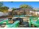 Backyard featuring a screened pool, with a fire pit, and green chairs, perfect for outdoor relaxation and entertainment at 40140 Palm St, Lady Lake, FL 32159
