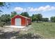 Barn on a farm, featuring a large garage door and windows, and a sprawling grass at 40143 Babb Rd, Umatilla, FL 32784