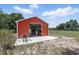 Barn with open garage door offering scenic views of a serene farm landscape on a sunny day at 40143 Babb Rd, Umatilla, FL 32784