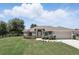 Charming front exterior with well-manicured lawn and garden, attached garage, and fenced yard at 40143 Babb Rd, Umatilla, FL 32784