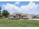 Charming front exterior with well-manicured lawn and garden, attached garage, and fenced yard at 40143 Babb Rd, Umatilla, FL 32784