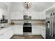 Well-lit kitchen offers white cabinets, stainless steel appliances, and granite countertops at 40143 Babb Rd, Umatilla, FL 32784